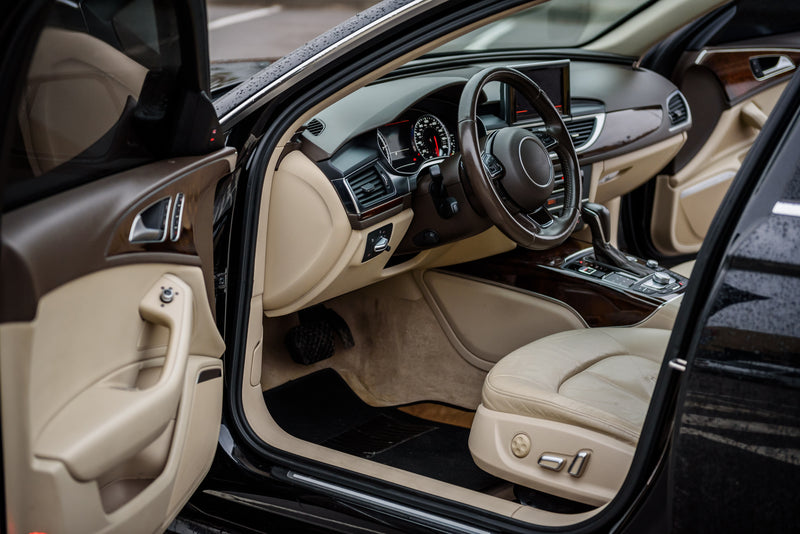 a peak into of a cars beige and dark brown interior 