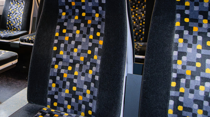 Close-up of a patterned seat cover with a geometric design in a vehicle interior.